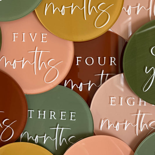 Set of 13 acrylic baby milestone discs. Customizable disc included. Handpainted in 6 warm, cheery colours with white font.